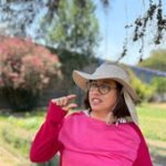 a woman wearing a hat in a farming setting