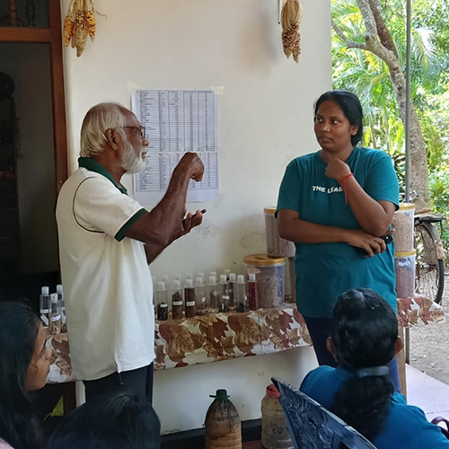two people speaking to each other and other participants at a seed workshop in Sri Lanka